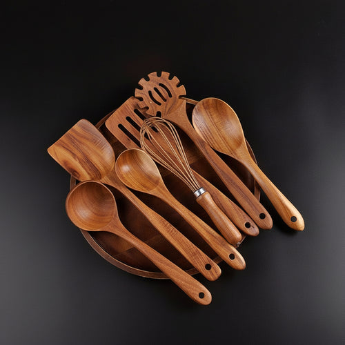 Set of wooden kitchen utensils including spoons and a spatula on a dark surface.