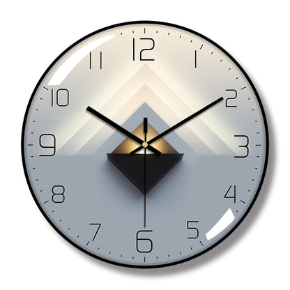Round wall clock with a black frame, black hands and numerals, and layered cream, gray, and black triangular artwork.