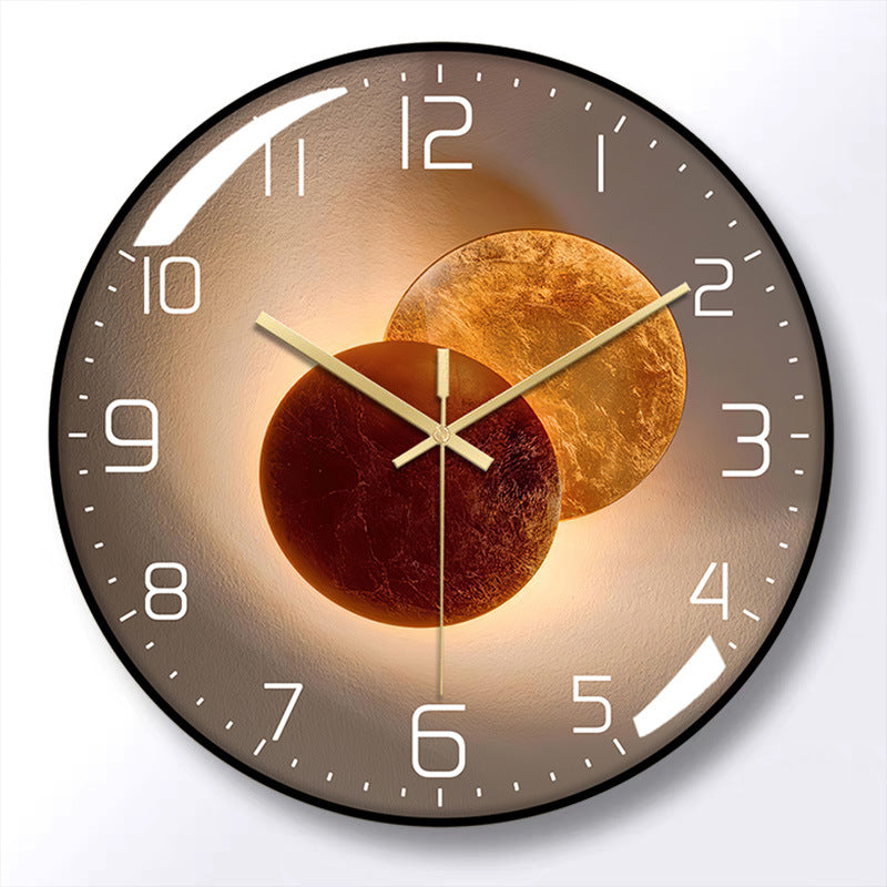 Round wall clock with a black frame, brown face, white numerals, and gold-colored hands over overlapping bronze circle artwork.