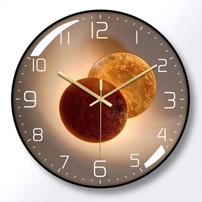 Round wall clock with a black frame, brown face, white numerals, and gold-colored hands over overlapping bronze circle artwork.