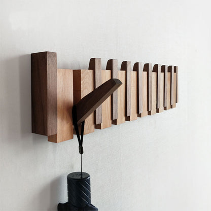 Solid wood black walnut wall-mounted coat rake with an umbrella hanging on it.