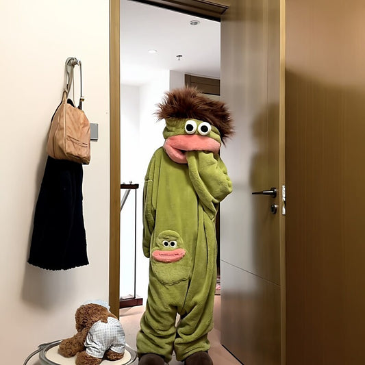 Person standing in a doorway wearing green plush fish onesie pajamas with matching character slippers.