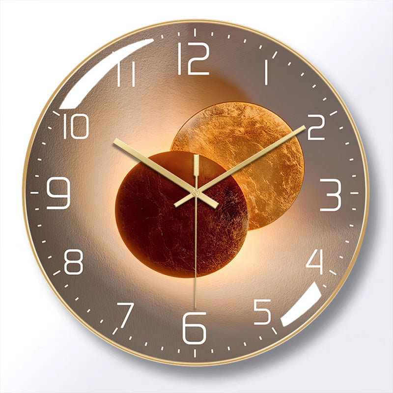 Round wall clock with a gold-colored frame, brown face, white numerals, and gold-colored hands over overlapping bronze circle artwork.