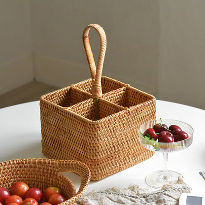 Woven decorative basket sitting on table with a cup of cherries next to it.