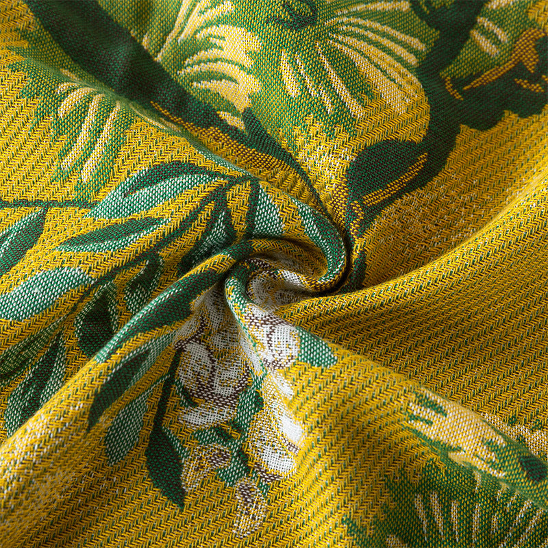 Close-up of the woven cotton fabric featuring yellow, green, and white botanical details.