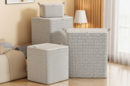 Four gray lidded fabric storage bins in different sizes arranged beside a sofa.