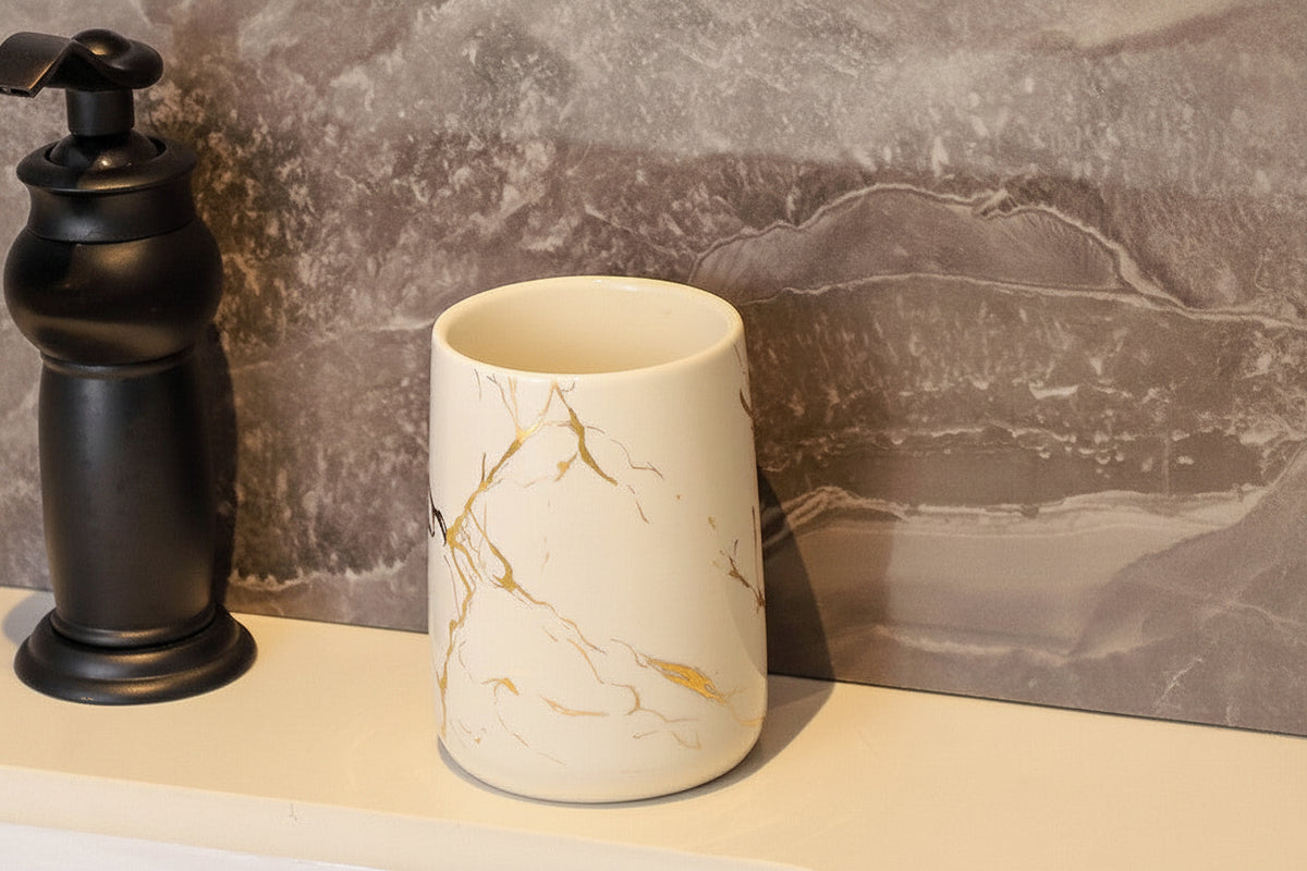 White ceramic bathroom tumbler with gold marble pattern measuring 10 centimeters tall and 8.5 centimeters wide