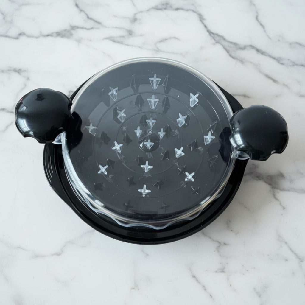 Top view of a closed black chicken shredder with handles and transparent lid