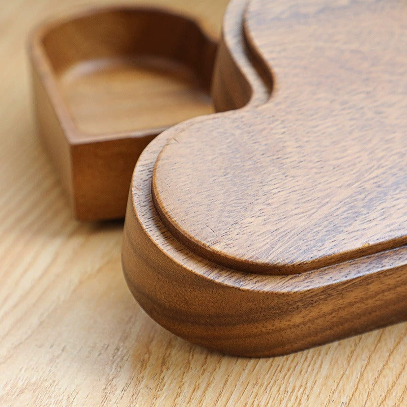 Close up of heart-shaped wooden snack tray slightly stacked on another heart-shaped wooden snap tray