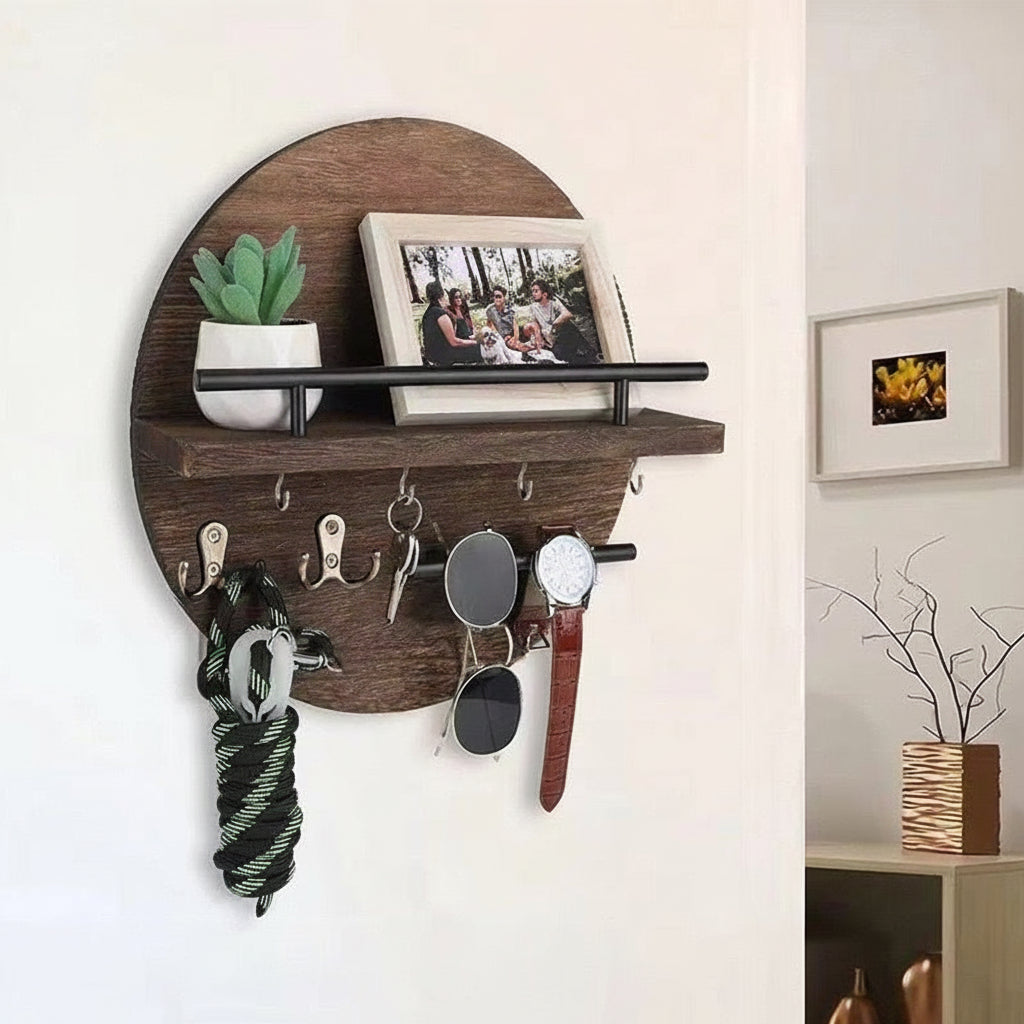 Dark brown round wooden wall shelf with hooks holding keys, sunglasses, a watch, and a leash