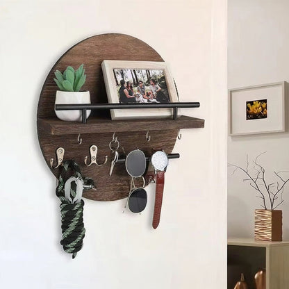 Dark brown round wooden wall shelf with hooks holding keys, sunglasses, a watch, and a leash