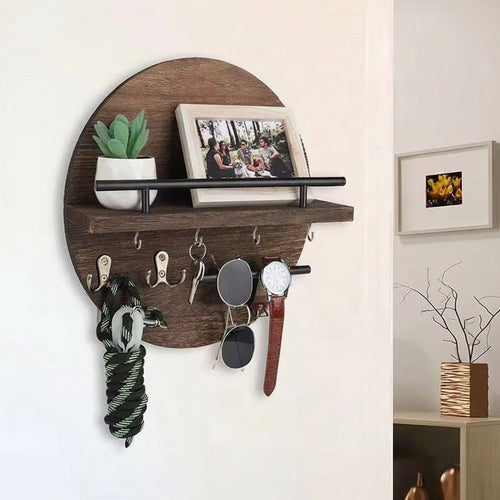 Dark brown round wooden wall shelf with hooks holding keys, sunglasses, a watch, and a leash