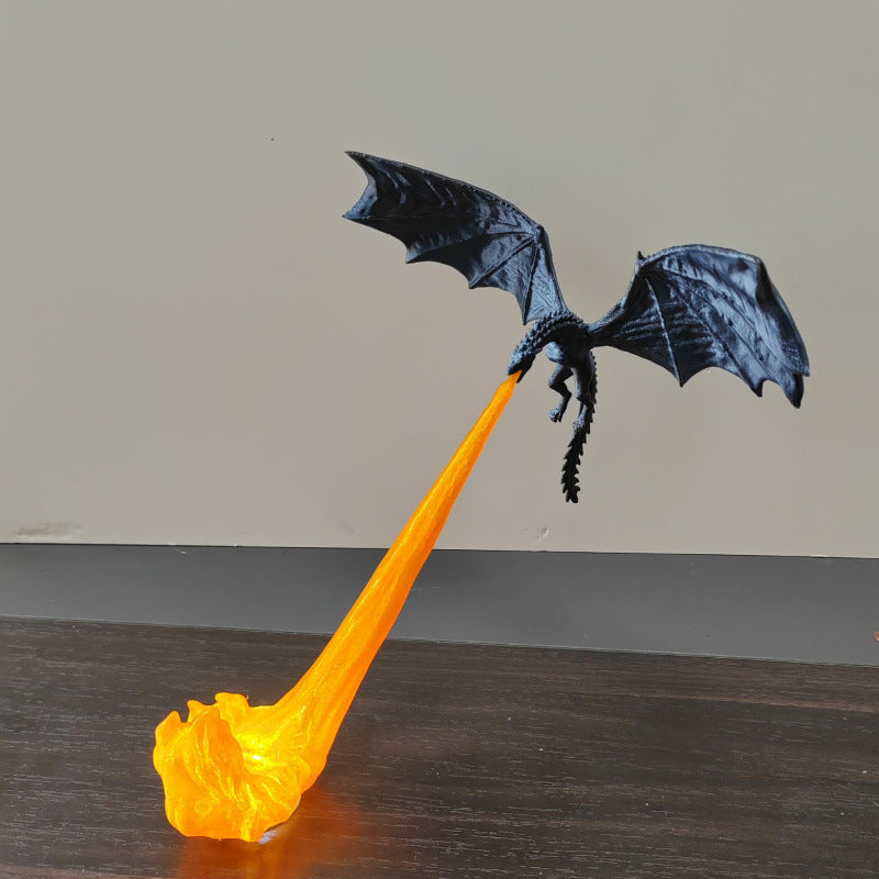 Black dragon night light projecting an orange flame effect onto a tabletop