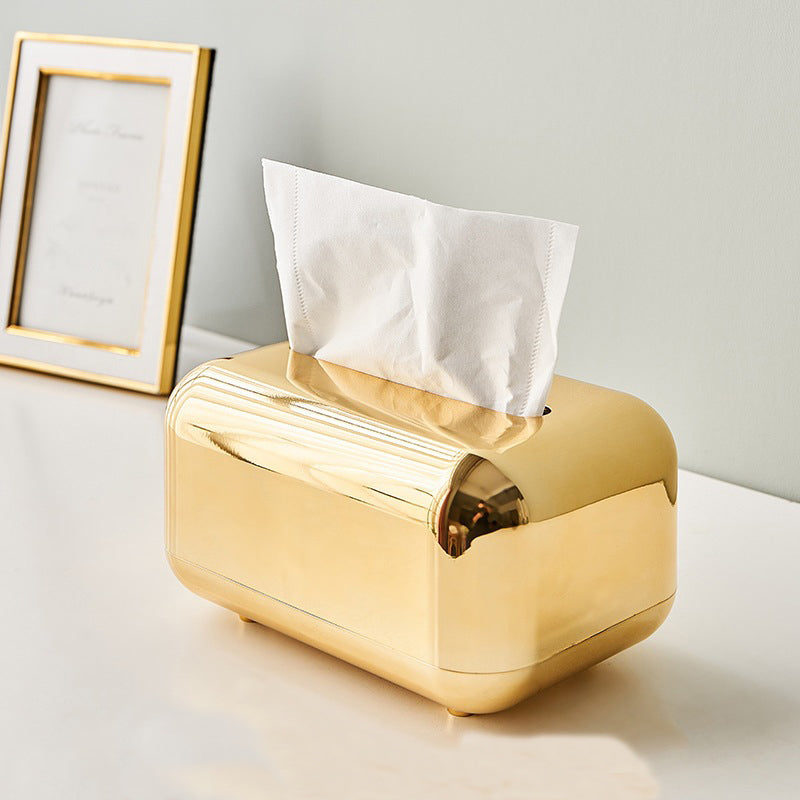 Gold tissue box with rounded corners and a reflective finish, displayed on a white tabletop.
