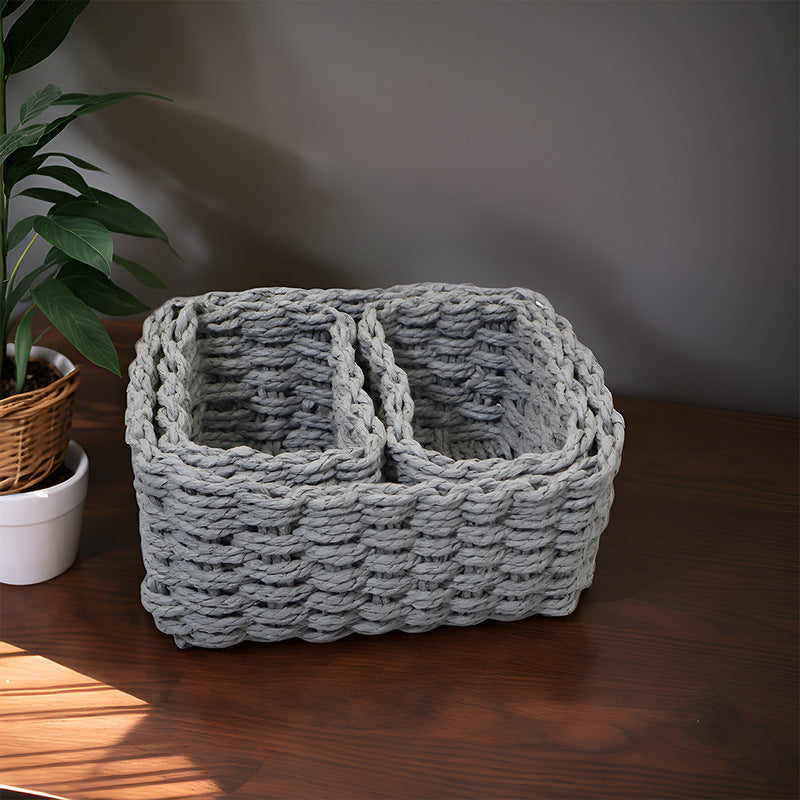 Gray rectangular woven storage basket with two smaller baskets on a wooden table