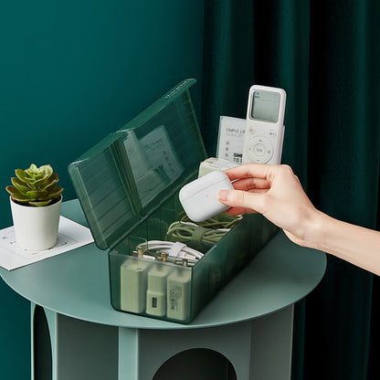 Open green cable organizer box holding charging cords, adapters, and small electronic accessories.