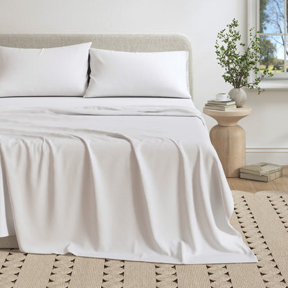 Neatly made bed with white bedding in a bedroom setting.