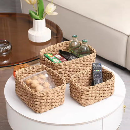 Three natural woven storage baskets holding snacks, bottled drinks, and a remote on a living room table