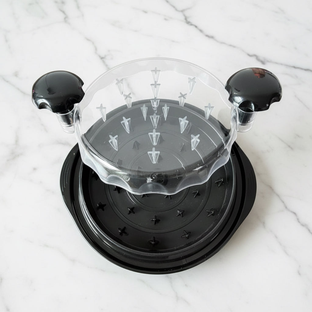 Open black chicken shredder showing the interior shredding teeth and side handles