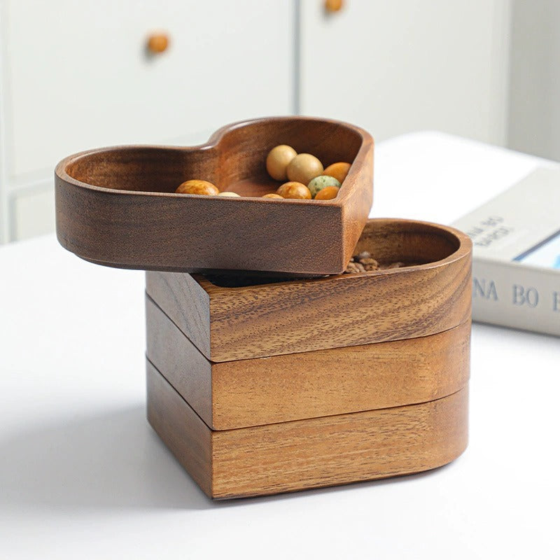 Multiple wooden heart-shaped snack tray stacked on top of each other with the top one rotated to display its design