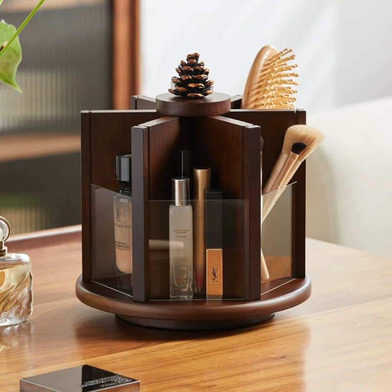 Rotating wooden makeup organizer holding cosmetics, makeup brushes, perfume, and a hairbrush on a vanity