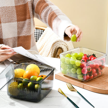Clear and gray lidded storage containers organizing grapes, tomatoes, citrus fruit, and vegetables