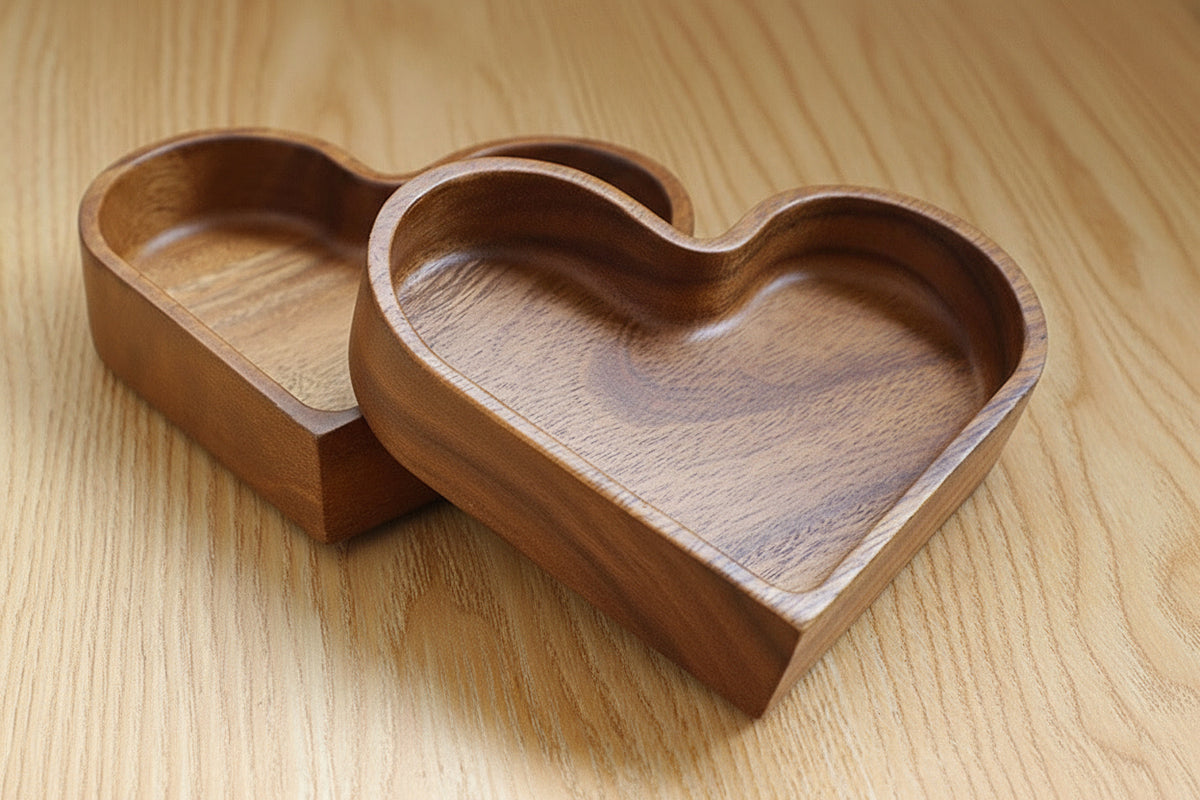 Heart-shaped wooden serving tray with divided compartments filled with nuts and snacks