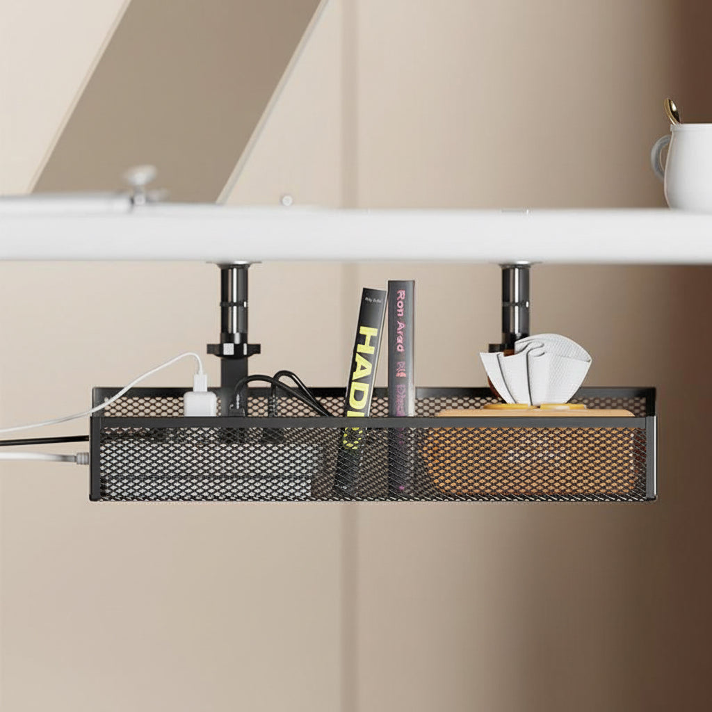 Black under-desk mesh organizer storing a power strip, books, cables, and napkins beneath a desk