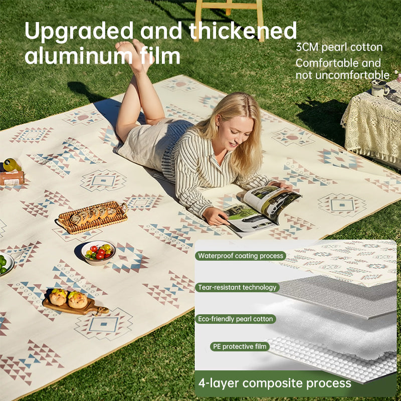 Large padded picnic blanket on grass showing waterproof layered construction with pearl cotton and protective film